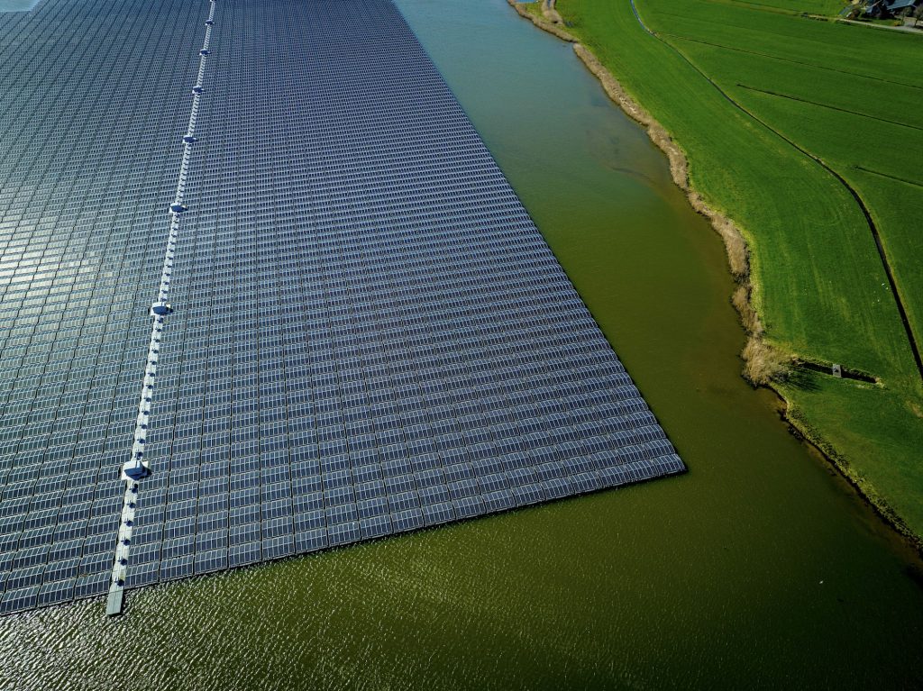 Aerial view of a solar farm next to a body of water